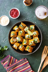 Grilled corn with white sauce and herbs. BBQ. Picnic. Vegetarian food. Diet.