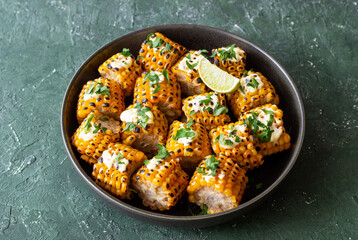 Grilled corn with white sauce and herbs. BBQ. Picnic. Vegetarian food. Diet.