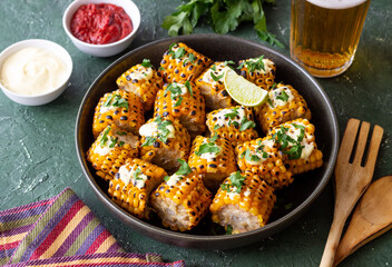 Grilled corn with white sauce and herbs. BBQ. Picnic. Vegetarian food. Diet.