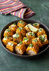 Grilled corn with white sauce and herbs. BBQ. Picnic. Vegetarian food. Diet.