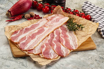 Sliced pork bacon over board