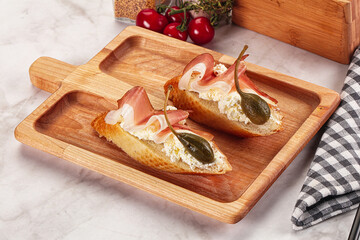 Bruschetta with jamon and caper berries