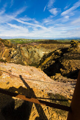 Portrait style view looking over the disused open cast copper mine at Parys Mountain looking towards the Snowdonia Mountain Range in the distance, Amlwch, Anglesey, Gwynedd 