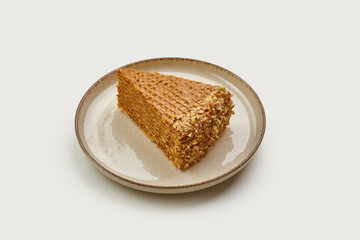 A nostalgic slice of classic waffle cake, layered with creamy caramel and topped with crushed nuts.