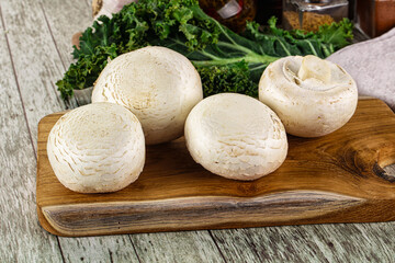 White champignon mushrooms heap over board