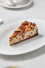Decadent Nut and Chocolate Chip Cheesecake Slice on Elegant White Plate