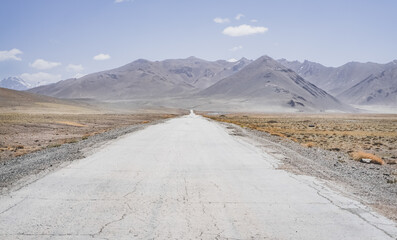 Asphalt road of the Pamir Highway in the valley of the Tien Shan Mountains in Tajikistan in the...