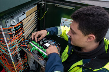Técnico de fibra ótica a realizar reparo em armário para restaurar o acesso à rede de clientes afetados pela avaria