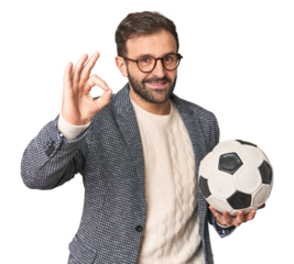 Hispanic male soccer coach in studio cheerful and confident showing ok gesture.
