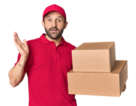 Hispanic male courier with boxes surprised and shocked.