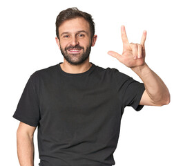 Fototapeta premium Studio portrait of young Hispanic male showing a horns gesture as a revolution concept.
