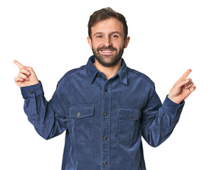 Fototapeta premium Studio portrait of young Hispanic male pointing to different copy spaces, choosing one of them, showing with finger.