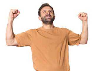 Studio portrait of young Hispanic male raising fist after a victory, winner concept.