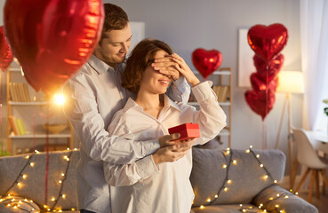 Valentine day secret surprise giving, happy loving couple, man and woman holding red box, sharing...