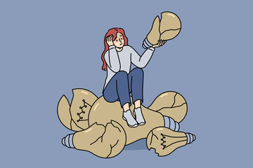 Loser woman sits on broken light bulbs symbolizing bad ideas and lack of further plan. Loser girl suffers from constant mistakes that negatively affect psychological health and mood.