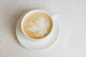 cup of cappuccino coffee on white table, coffee shop	