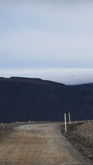 Vue aérienne au drone professionnel d’une voiture en Islande sur route désertique volcanique...