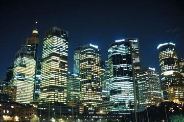 Naklejka premium City Skyline at Night with Illuminated Skyscrapers
