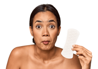 Filipino woman with sanitary pad in studio shrugs shoulders and open eyes confused.