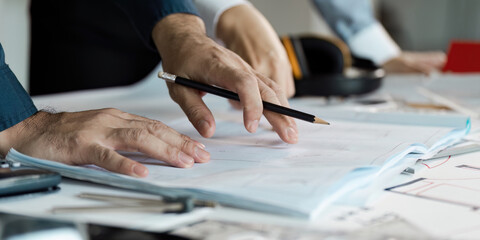 Architects Planning Modern House Construction with Blueprints and Tools on Desk