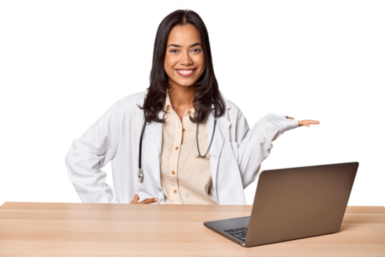 Young Filipino doctor with laptop in studio showing a copy space on a palm and holding another hand on waist. - Powered by Adobe
