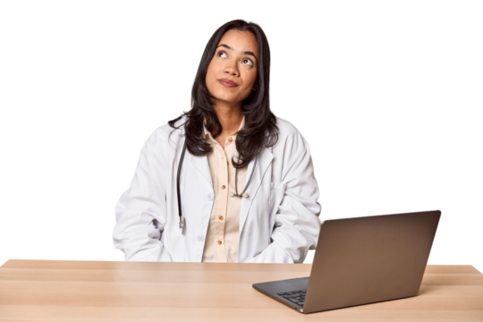 Young Filipino doctor with laptop in studio dreaming of achieving goals and purposes