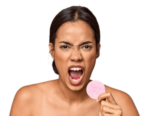 Woman holds facial sponge in studio screaming very angry and aggressive.