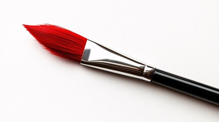 Fototapeta premium Bright red brush resting on a clean surface, prepared for artistic creation