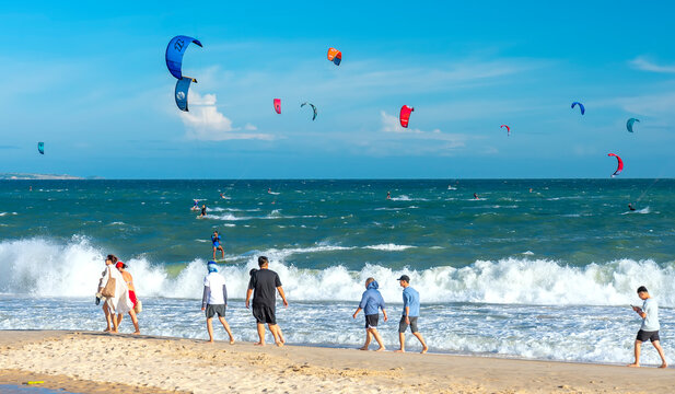 Mui Ne, Vietnam - December 28th, 2024: Kite-surfing. Many silhouettes of kites in the sky of Mui Ne bay and performs all kinds of stunts. The concept of sports, health, recreation. Holidays on nature