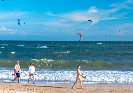 Mui Ne, Vietnam - December 28th, 2024: Kite-surfing. Many silhouettes of kites in the sky of Mui Ne bay and performs all kinds of stunts. The concept of sports, health, recreation. Holidays on nature