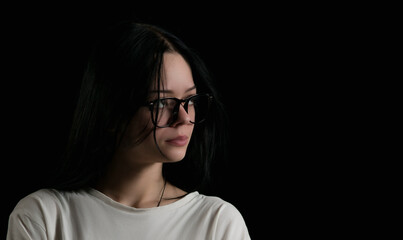 Fototapeta premium Portrait image of a young girl with glasses in the dark