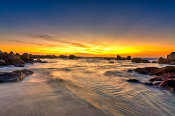 Beautiful Sunset beach with waves, sand, sunset sky gradually down to the horizon. Seascape to relax the soul