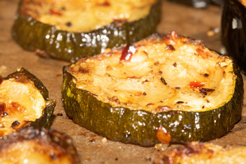 A roasted sliced seasoned aubergine eggplant courgette with salt and herbs cooked in the oven close up