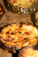 A roasted sliced seasoned aubergine eggplant courgette with salt and herbs cooked in the oven close up