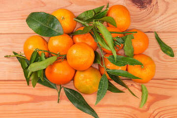 Tangerines with small twigs with leaves on a rustic table