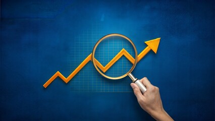 Hand holding a magnifying glass over a rising growth graph on a blue background