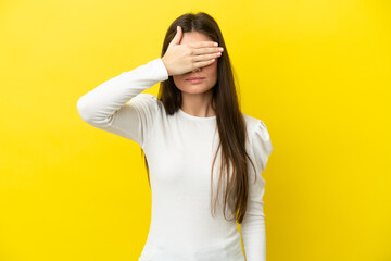 Young caucasian woman isolated on yellow background covering eyes by hands. Do not want to see...