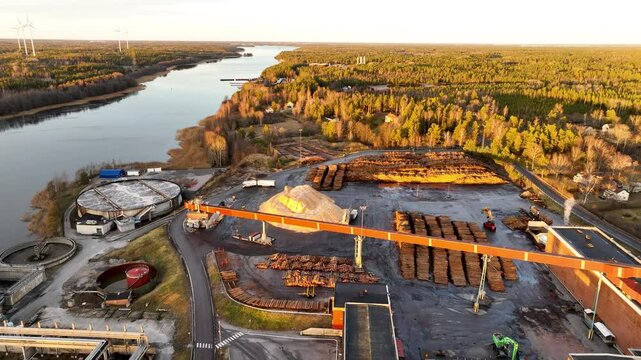 Industrial conveyor belt moving wood at lumber paper mill near river