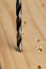 metal drill bit and pine wood board during operation
