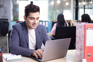 Office Operations Manager Typing On Laptop At Workplace