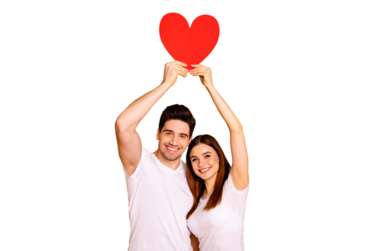 Close up photo two beautiful people she her he him his guy lady hold hands arms heart shape form paper postcard above head excited best emotions wear casual white t-shirts isolated yellow background