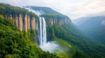 Fototapeta premium Madakaripura Waterfall stands as a majestic natural wonder, cascading down from the lush green forest canopy with an awe inspiring height that captures the beauty and power of nature.