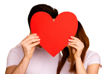 Close up photo beautiful she her he him his guy lady hiding kissing faces hold hands arms big heart shape paper postcard best emotions in love wear casual white t-shirts isolated yellow background