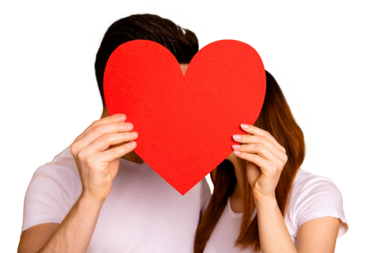 Close up photo beautiful she her he him his guy lady hiding kissing faces hold hands arms big heart shape paper postcard best emotions in love wear casual white t-shirts isolated yellow background
