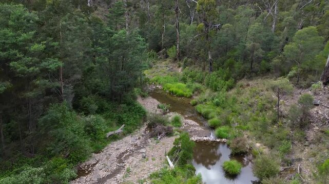 Aerial view moving over creek in gold country Victoria Australia