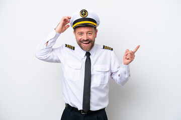 Airplane middle age pilot isolated on white background surprised and pointing finger to the side