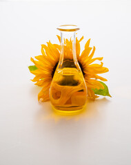 Sunflower Oil In A Clear Bottle Beside A Bright Sunflower blossom