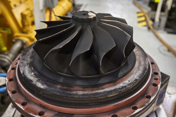 Turbocharger turbine blades covered in carbon soot deposits, close up.