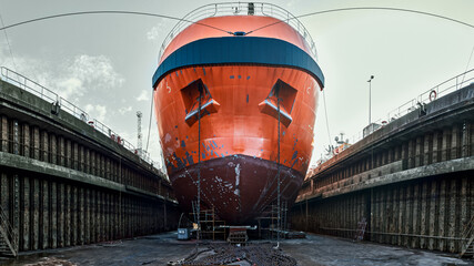 Panoramic view of a dry dock, with a ship on blocks at the bottom of the dry dock. 