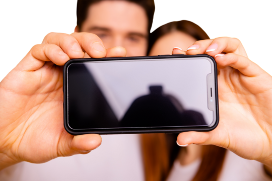 Close-up view portrait of two nice attractive people making taking selfie holding in hands new device gadget isolated over vivid shine bright yellow background